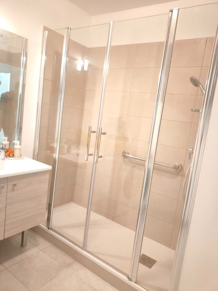Salle de bains PMR après travaux : douche de plain-pied et barres d’appui